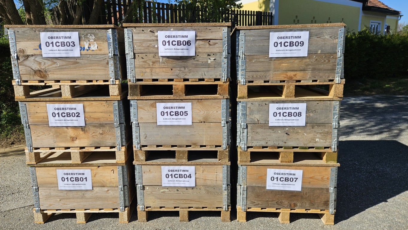 Beschriftete Mehrwegholzpaletten mit DC-Kabelsträngen